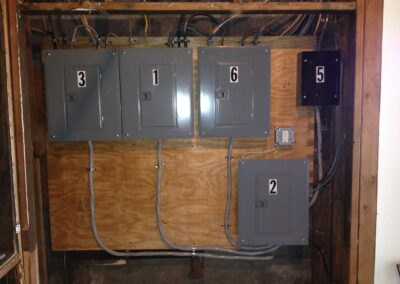 A set of labeled electrical panels mounted on a wooden board, with wires extending from each panel.